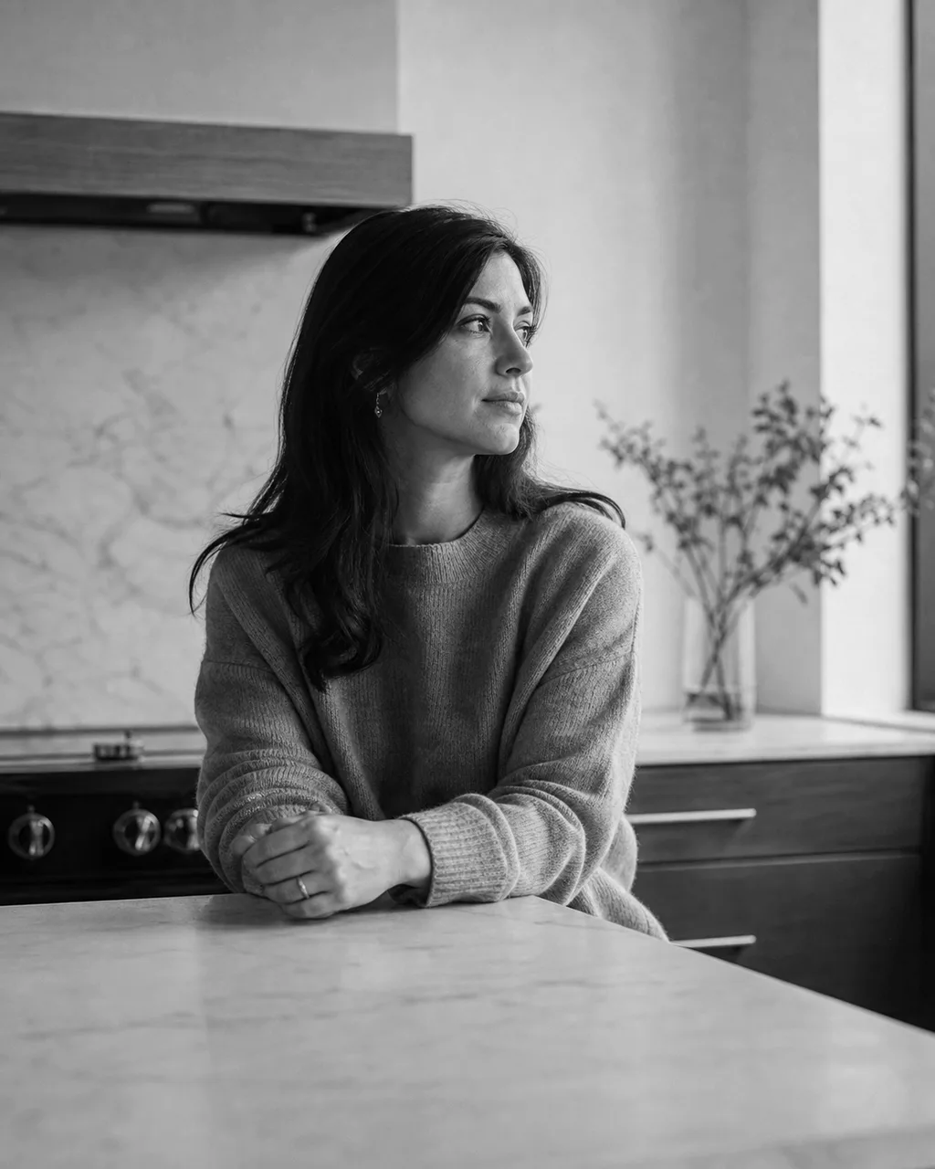 Sarah Mathur looking toward window light in her kitchen